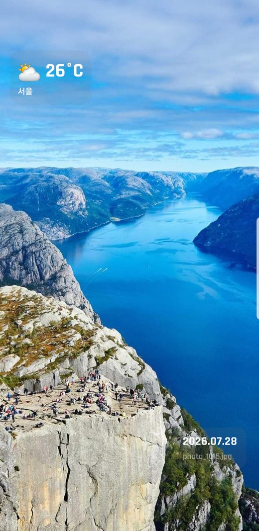 PicDock on an Android tablet showing a fjord photo with the current weather and clock